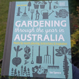 Book titled 'Gardening through the year in Australia' by Ian Spence with gardening-themed illustrations on a blurred natural background.