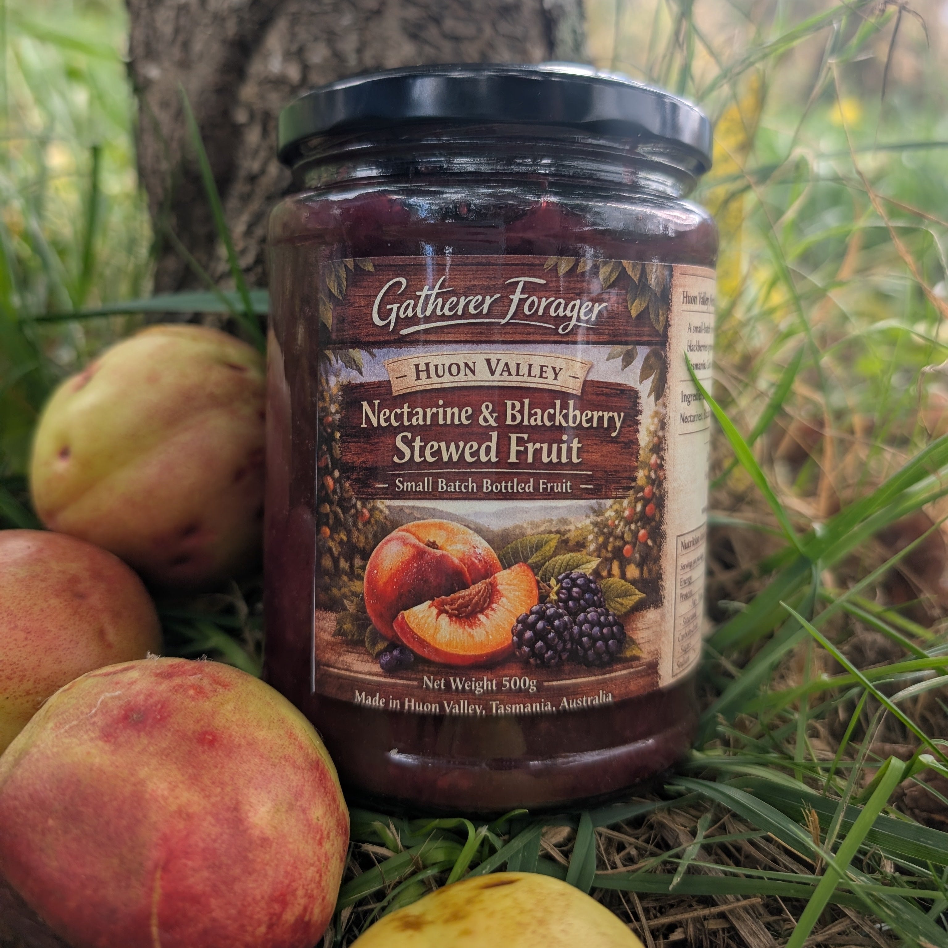 Jar of Huon Valley Nectarine & Blackberry Stewed Fruit on grass with peaches and a tree in the background