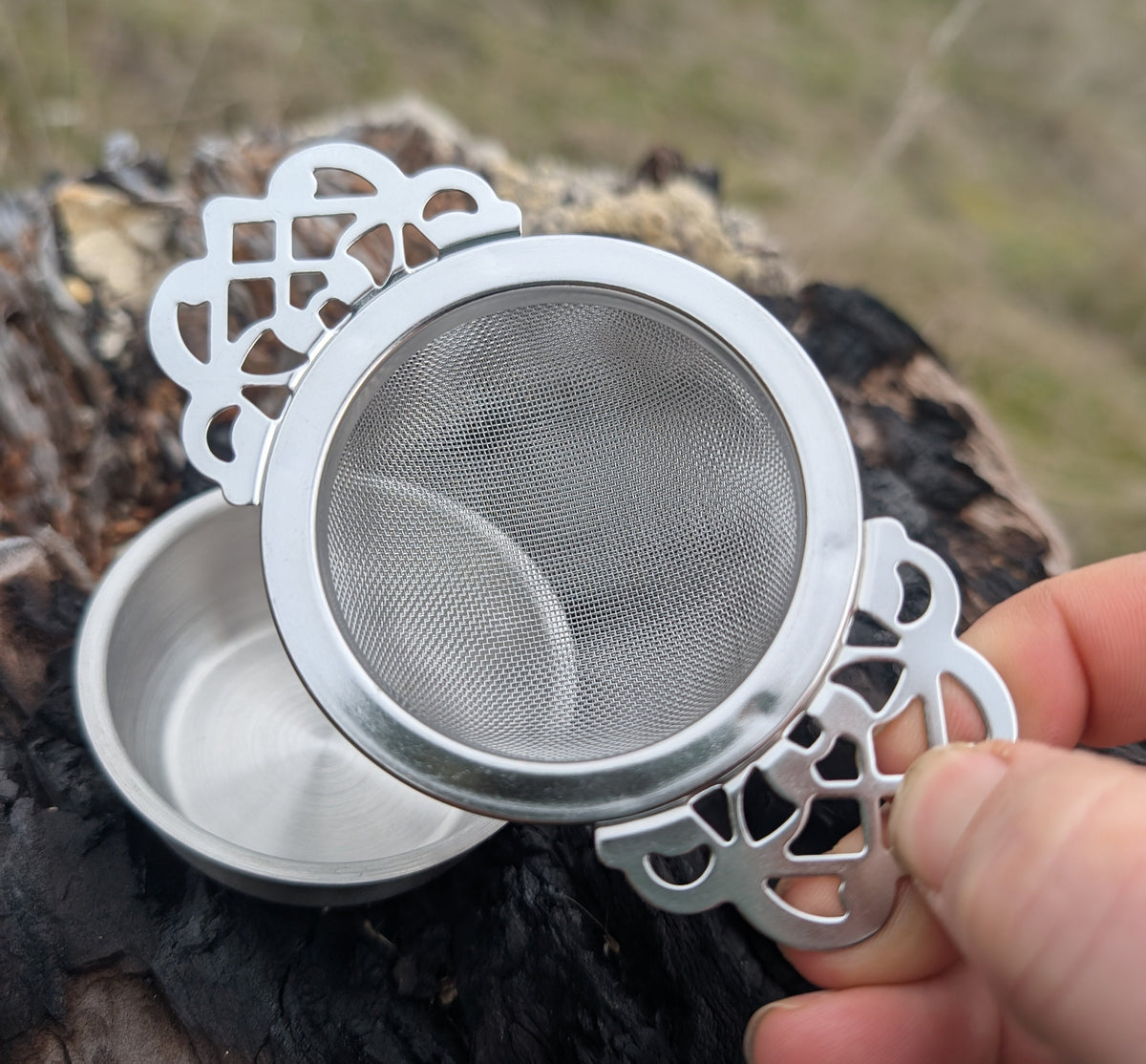 Elegant stainless steel tea strainer with lace handle and drip tray