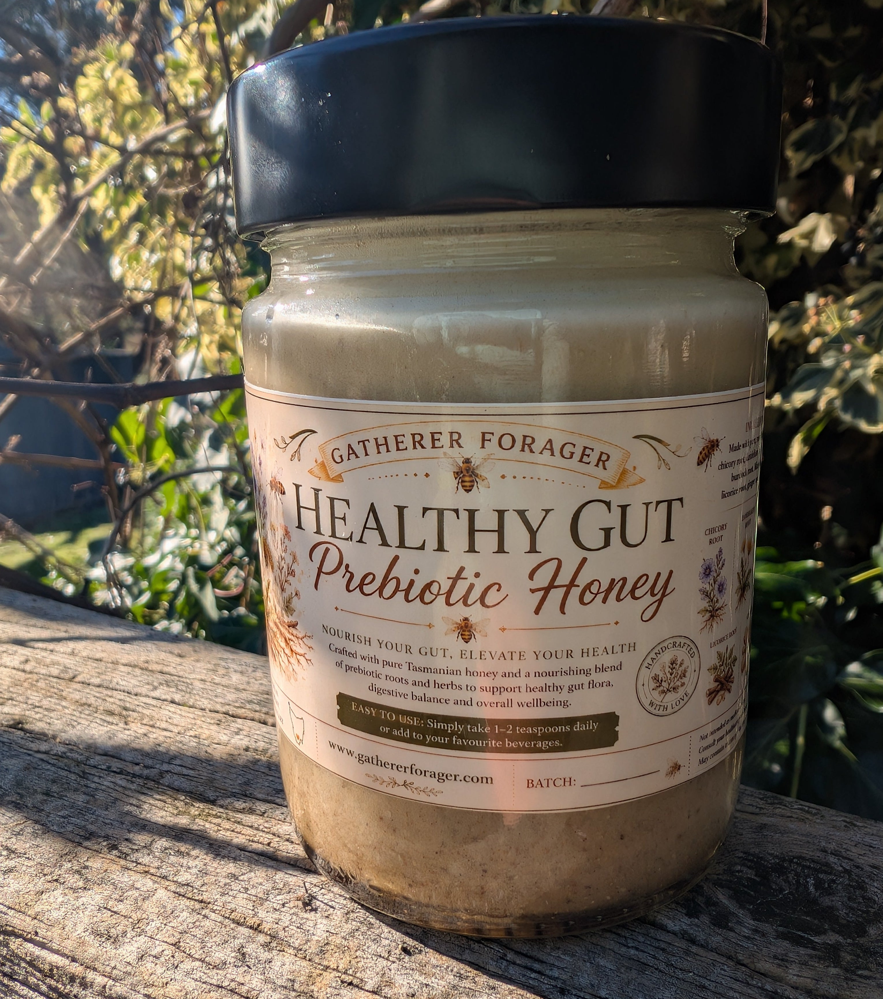 Jar of 'Healthy Gut Prebiotic Honey' on a wooden surface with a natural background