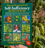 Book titled 'How can I be prepared with Self-Sufficiency and Survival Foods?' held in front of greenery.
