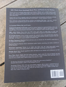 Back cover of sourdough without fail book with text and a barcode on a wooden surface