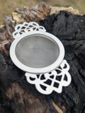 Close-up of intricate lace handle on Empress tea strainer