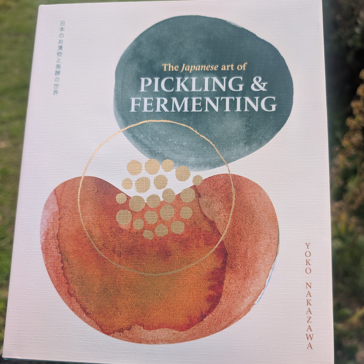 Book titled 'The Japanese Art of Pickling & Fermenting' held in front of a natural background